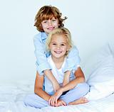 Portrait of young siblings in bed