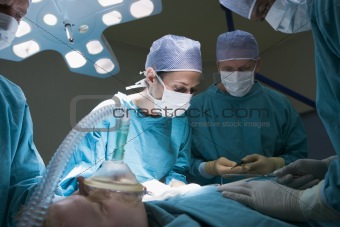 Two Surgeons Operating On A Patient