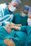 Three Surgeons Operating On A Patient
