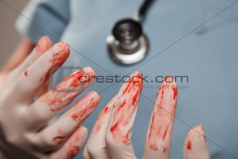 Abstract of Doctors Bloody Surgical Gloves, Scrubs and Stethoscope.