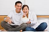 Attractive Asian Couple Eating Popcorn in Bed