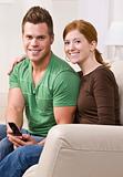 Attractive Young Couple Sitting Together on Couch