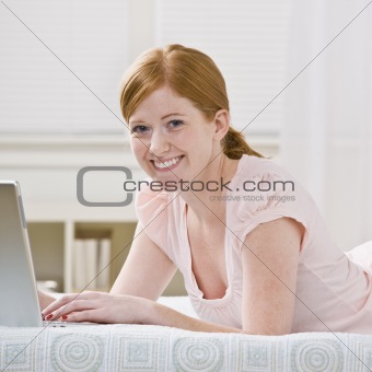 Cute Redhead Woman Lying Down with Laptop