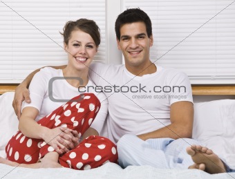 Smiling Couple Sitting in Bed