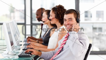 Young businessman working in a call center smiling at the camera