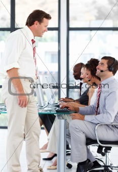 Senior manager talking to a worker in a call center