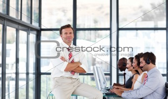 Mature manager with folded arms in a call center