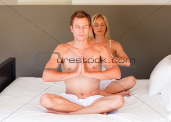 Young couples meditating on bed