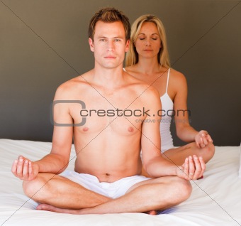 Handsome boy doing exercises on bed with his wife