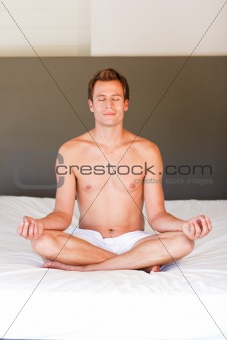 Young boy doing spiritual moves on bed
