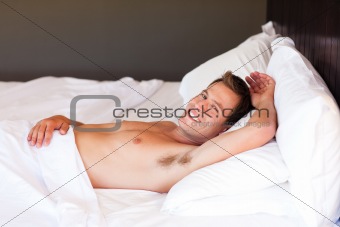 Smiling boy lying in bed