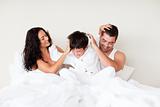 Couple and son playing in bed