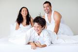 Family playing with his son in bed