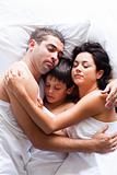 Happy family sleeping in bed 
