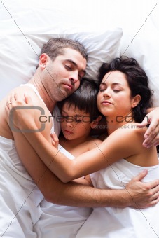 Happy family sleeping in bed 