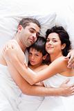 Happy family relaxing in bed 