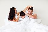 Couple and son having fun in bed