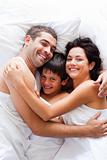 Happy family together in bed 