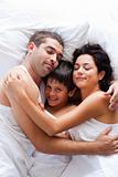 Happy family lying in bed 
