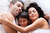 Portrait of a happy family sleeping in bed 