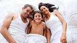 Family playing lying his son in bed