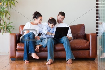 Parents and son playing with a laptop