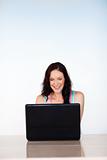 Smiling woman using a laptop with copy-space