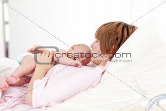 Woman kissing her newborn baby