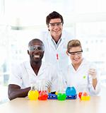 Scientists examining test-tubes smiling at the camera