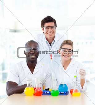 Smiling scientists examining test-tubes