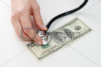 Doctor holding stethoscope against one hundred u.s. banknote