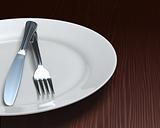 Clean plate & cutlery on dark woodgrain table