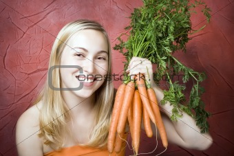 Smiling woman with fresh carrots