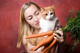 Smiling woman with cat and carrots