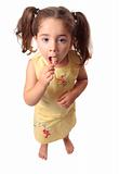 Little girl eating a lollipop candy
