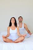 Young couples meditating on bed