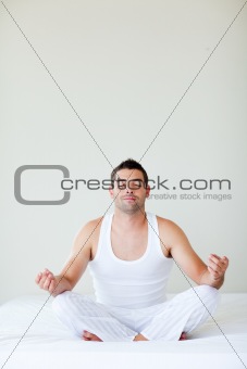 Man sitting on bed meditating