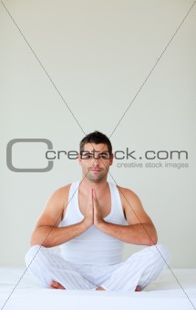 Man sitting on bed meditating with copy-space