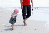 A little girl with her father at the beach.