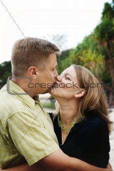 Portrait of a happy married couple kissing.
