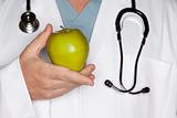 Male Doctor with Stethoscope Holding Green Apple.