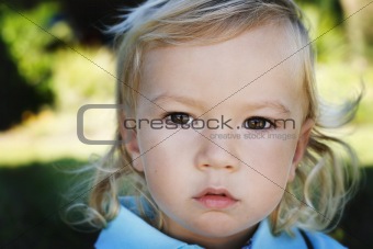 Close-up portrait of a serious looking little boy.