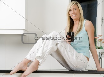 Lifestyle of woman sat in kitchen