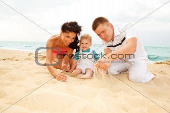 Mother, father and baby on beach
