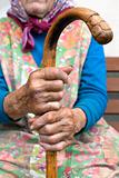 hand of an old peasant woman holding a walking stick

