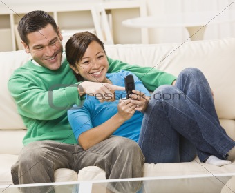 Mixed race couple watching TV together