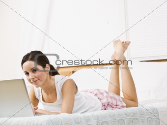Attractive girl lying down with Laptop.