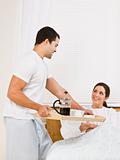 Man Serving Breakfast Tray to Woman
