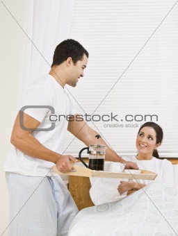 Man Serving Breakfast Tray to Woman