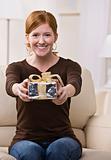 Woman Presenting Gift to the Camera